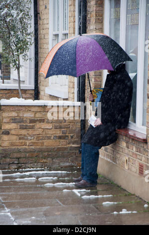 Londra, UK, domenica 20 gennaio 2013. Un uomo che ripara dalla neve sotto un ombrello a Londra. 2013 viene disattivato per un avviamento a freddo come gelo colpisce il Regno Unito. Nel corso del fine settimana del XIX Gennaio oltre dieci centimetri di neve sono caduti in alcune aree del Regno Unito con più la caduta della domenica e più atteso durante la settimana seguente. Foto Stock