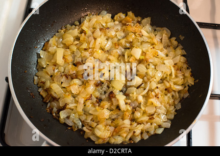 Onion friggere in una padella con il burro Foto Stock