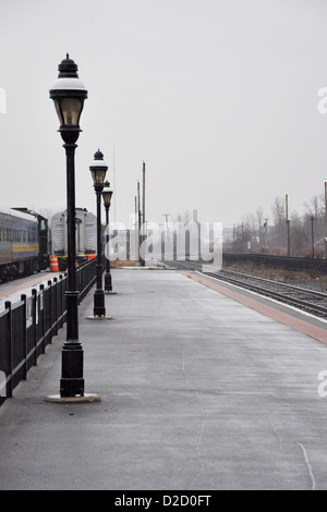 Treno vuoto piattaforma ad una stazione ferroviaria in un giorno nuvoloso. Foto Stock