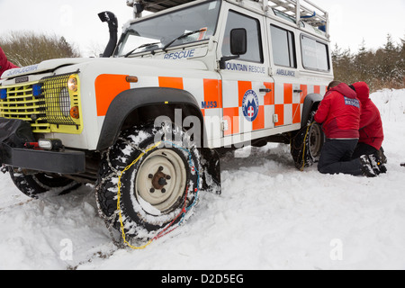 Scarborough & Ryedale Mountain Rescue team montaggio di catene da neve, durante un esercizio di Dalby Forest. Foto Stock