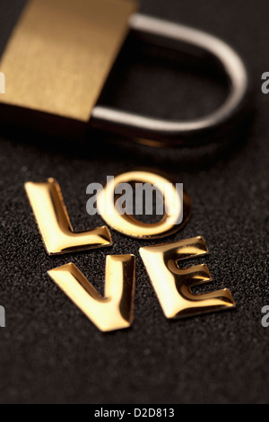 Singola parola 'amore' in oro scritte accanto a forma di lucchetto Foto Stock