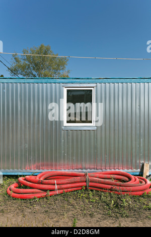 Conduttore rosso legato fino di fronte all edificio industriale Foto Stock