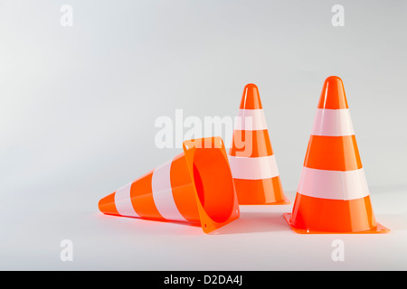 Un cono stradale giacente sul suo lato accanto a due piedi traffico coni Foto Stock