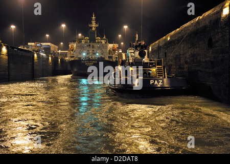 Due navi mercantili in transito attraverso il canale di Panama di notte. Nota acqua turbolenta come Gatun riempie di bloccaggio Foto Stock