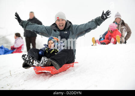 Padre e figlio slittano nello Shropshire. Inverno nevicare Gran Bretagna condizioni meteo inverni britannici divertimento slitta Foto Stock