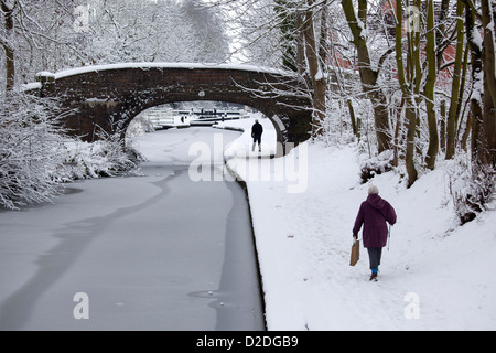 La gente camminare lungo un congelati Coventry canal in Atherstone, North Warwickshire. Foto Stock