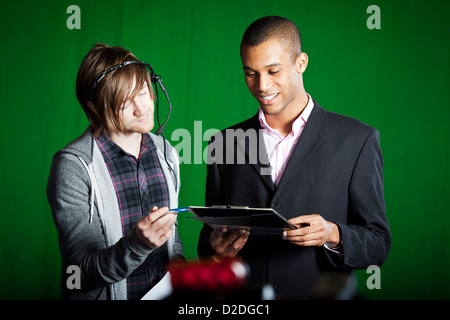Piano manager viene eseguito tramite script con un presentatore della televisione in una schermata verde studio. Foto Stock