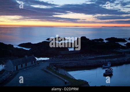 Midsummer mezzanotte crepuscolo sopra Ballintoy Harbour, County Antrim, Irlanda del Nord. Foto Stock