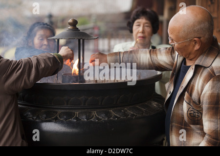 Il popolo giapponese bruciare bastoncini di incenso e di pregare presso il Tempio di Todai-ji di Nara, Giappone Foto Stock