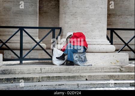 Donna dormire in Piazza San Pietro a Roma Foto Stock