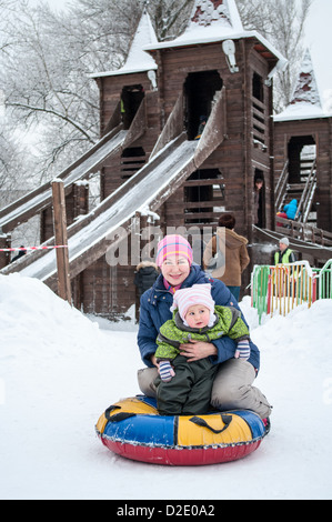 Madre e figlia vicino a slitte di legno con l'inverno sled per equitazione a San Pietroburgo, Russia Foto Stock