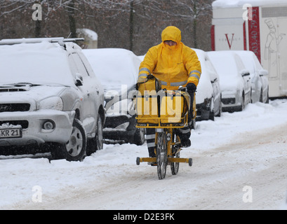 Berlino, Germania, un postino sulla sua bicicletta in presenza di neve Berlin Foto Stock