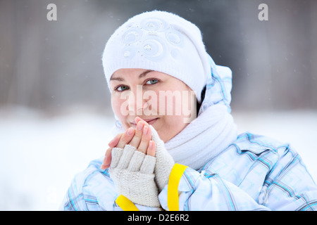 Giovane donna warming dita con bastoncini da sci in mani Foto Stock