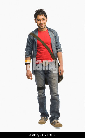 Studente universitario con una borsa a tracolla e sorridente Foto Stock