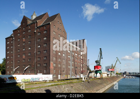 Duisburg, in Germania, un vecchio magazzino e il Portalwippkraene RWSG nel porto interno Foto Stock