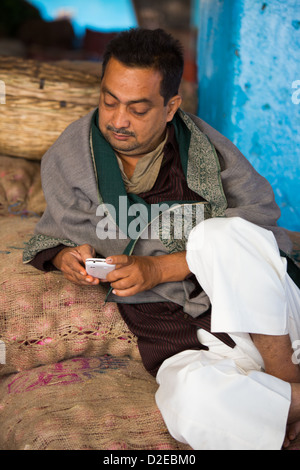 Fornitore utilizzando uno smartphone nel mercato ortofrutticolo, Ahmedabad, Gujarat, India Foto Stock