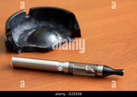 Chiusura del portacenere pieno di sigarette, con l'uomo nel lavoro in  background sul computer portatile e fumare in luoghi chiusi su la mattina  presto Foto stock - Alamy