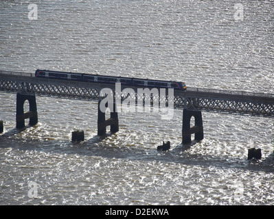 Treno Scotrail sul Tay rail bridge, Dundee, Tayside, Scozia, i pilastri del vecchio ponte visibile nella parte anteriore Foto Stock