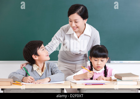 Ritratto di Allegro scolari e insegnante in classe Foto Stock