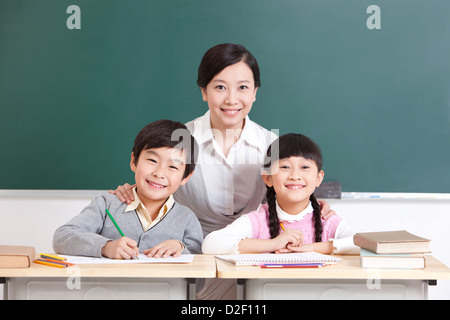 Ritratto di Allegro scolari e insegnante in classe Foto Stock