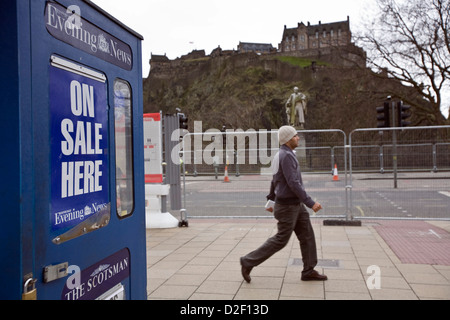 Venditore a vendere lo Scotsman e Edinburgh Evening News quotidiani da una cabina in Princes Street, Edinburgh Foto Stock