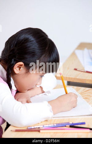 Bella la scolaretta iscritto in aula Foto Stock