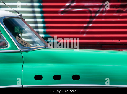 Americano classico anni cinquanta auto viene utilizzato come un Taxi con sfondo di graffiti, Avana, Havana, Cuba Foto Stock