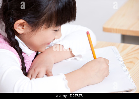 Bella la scolaretta iscritto in aula Foto Stock