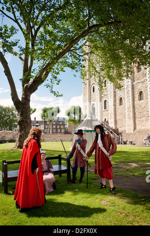 Gli attori in costume in piedi nella motivazione della Torre di Londra di fronte alla Torre Bianca. Inghilterra, Regno Unito Foto Stock