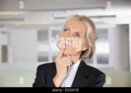 Riflessivo senior imprenditrice cercando in office Foto Stock