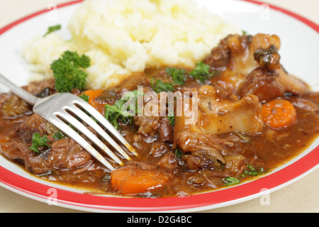 Un pasto di inglese stufato di coda di vitellone, servita con purea di patate e guarnite con prezzemolo Foto Stock