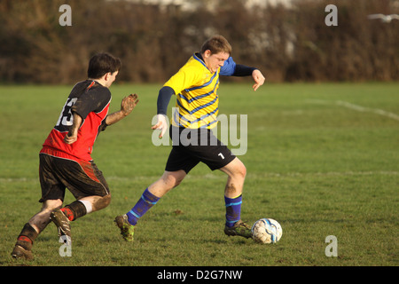 Due uomini che giocano a calcio in un pomeriggio soleggiato Foto Stock