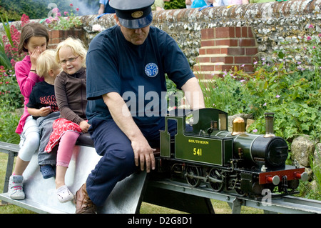 I membri del pubblico godetevi le attrazioni in un inglese tradizionale fiera estiva. Foto Stock