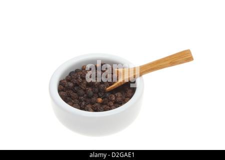 Pepe nero in grani con un cucchiaio di legno in un ramekin isolata contro bianco Foto Stock