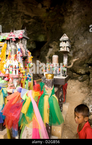 Offerte di portare buona fortuna al Princess' tempio nella grotta nella rupe di Hat Tham Phra Nang; Ao Nang, provincia di Krabi. Della Thailandia Foto Stock