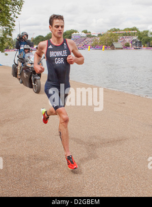 Jonathan Brownlee, in esecuzione nel 2012 Olympic uomini Triathlon in Hyde Park, Londra seguita dalla troupe cinematografica sulla bici del motore. Foto Stock