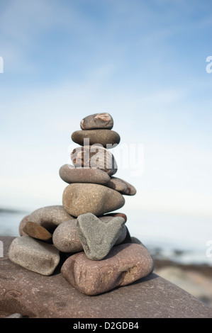 Di pietra a forma di cuore con una pila di pietre sulla spiaggia a Porlock Weir, Somerset, Inghilterra, Regno Unito Foto Stock