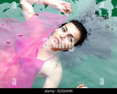 Donna flottante in una piscina sulla sua schiena Foto Stock