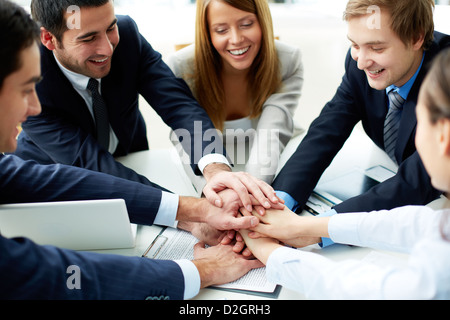 Immagine di business partner che fanno mucchio di mani alla riunione Foto Stock