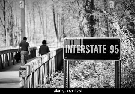 Un paio di camminare su un ponte al di sopra della pianura alluvionale del piccolo fiume Patuxent in Columbia, Maryland passando sotto la I-95 Foto Stock