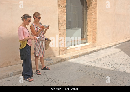Due donne in vacanza a Oliva, Spagna la consultazione di una mappa turistica Foto Stock