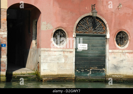 Dettaglio di una porta che conduce direttamente sul canale a Venezia eventualmente per una barca dicendo Divieto d'ormeggio - vietato ormeggio Foto Stock