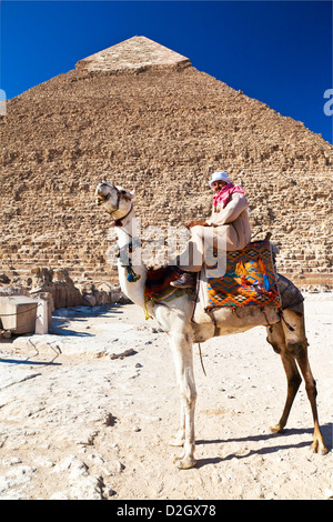 Driver del cammello pone di fronte della piramide di Khafre/Chefren/Chephren, la seconda più grande piramide egizia di Giza vicino al Cairo, Egitto. Foto Stock