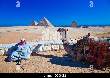 Un cammello driver con cammello presso la grande piramide complesso alla Necropoli di Giza vicino al Cairo, Egitto. Foto Stock