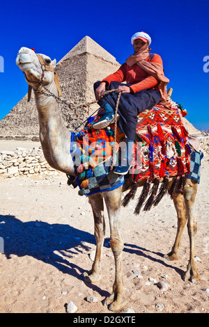 Driver del cammello pone di fronte della piramide di Khafre o Chefren, secondo grande egiziana antica Piramide di Giza vicino al Cairo, Egitto. Foto Stock