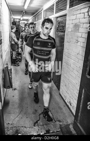 Giocatore di Rugby passeggiate fuori di spogliatoio lungo un corridoio per il passo. Foto Stock