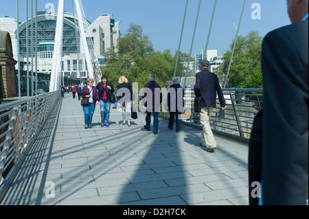 Londra, Southbank, Riverside, Embankment, Hungerford Bridge pendolari turisti attraversando a piedi il ponte in una giornata di sole Foto Stock