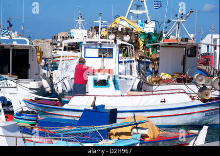 Pescatore greco a bordo di una barca ormeggiata nel porto di Naoussa, sul Greco Cyclade isola di Paros. Foto Stock