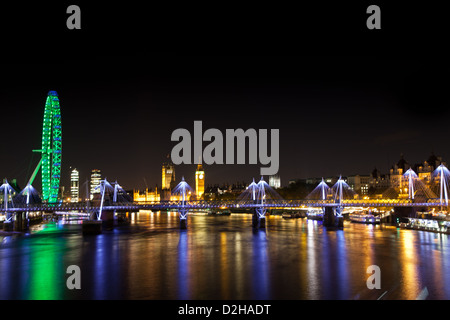 Una vista da Waterloo bridge verso il Parlamento che mostra il London Eye illuminato in verde. Foto Stock