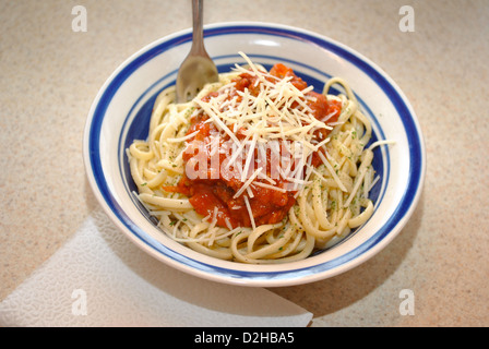 Linguini, il sugo di pomodoro e formaggio grattugiato in una ciotola Foto Stock